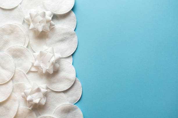 istock Cotton pads with white flowers for removing makeup on a blue background close-up. copy space. place for text 1138087583