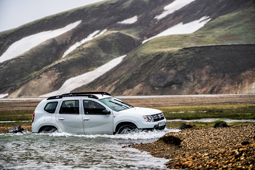 Landmannalaugar, Iceland - July 2, 2018: 4WD vehicle car travel off road in landscape of Landmannalaugar in highland of Iceland, Nordic, Europe. The place is famous for summer outdoor trekking way.