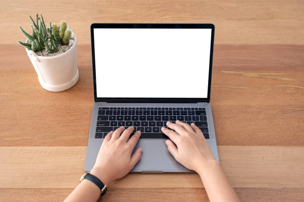 istock a woman using and typing on laptop with blank white screen on wooden table 1138089698