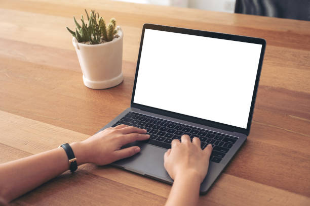 istock a woman using and typing on laptop with blank white screen on wooden table 1138089703