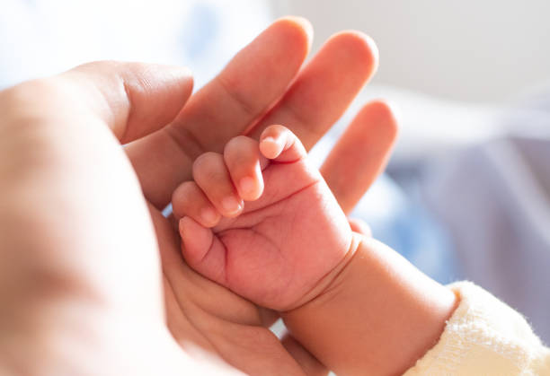 istock Mother hand holding baby hand 1138095292