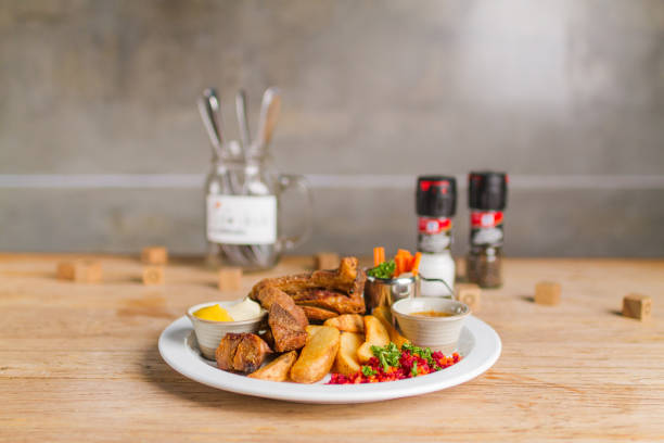 istock Deep fried pork knuckle with fried potatoes, mix vegetables, dipping sauce and spicy sauce on wooden table 1138097106