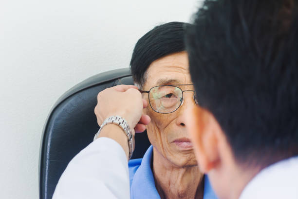 istock Optician male hands put glasses on elderly man testing his eye, ophthalmology concept. 1138098862