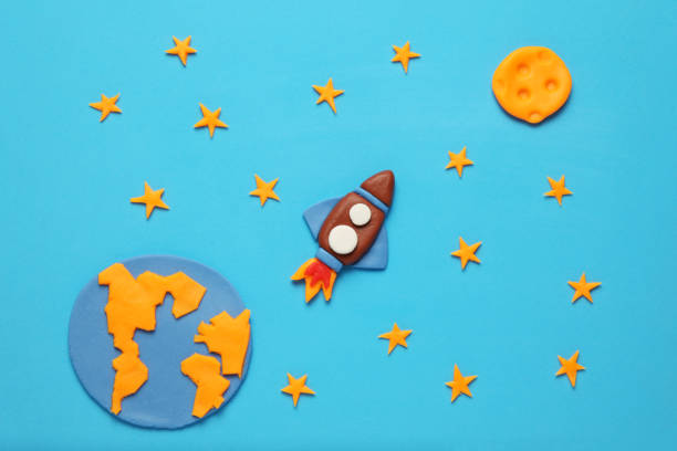 istock Creative craft plasticine rocket in open space, astronaut dreams. Stars, planet earth and moon. Cartoon art 1138102208