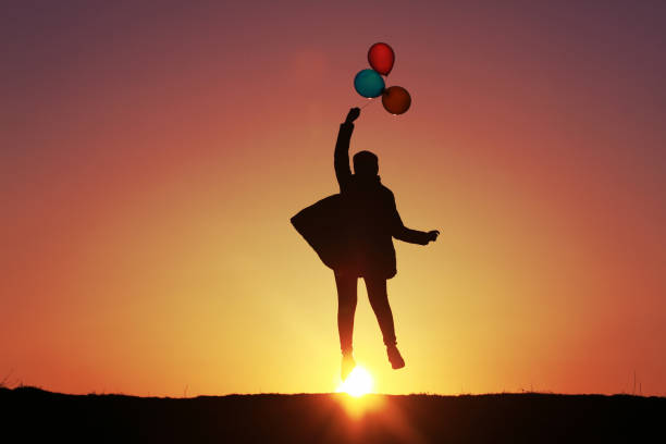 ragazza vola con palloncini al tramonto, palloncini multicolori, bellissimo tramonto del cielo - balloon moving up child flying foto e immagini stock