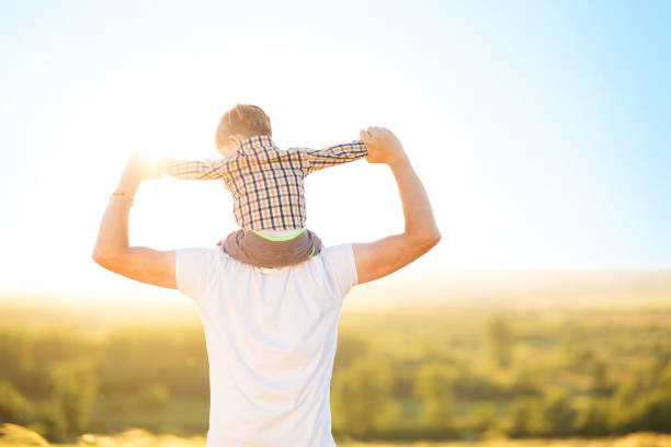 istock Father with his son sitting on his neck over sunset 1138105699