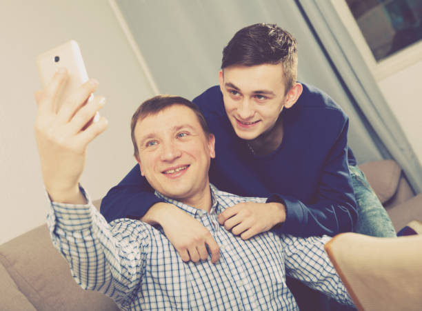 istock Guy with his father are resting and taking selfie by phone 1138106465