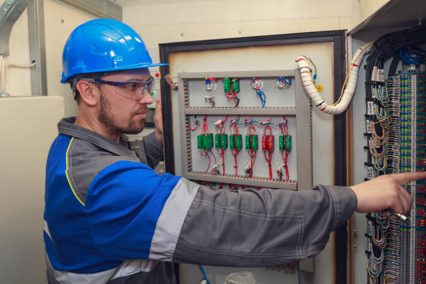 istock electromechanic in electrical safety gloves holds power cable, cabling connection of high voltage power electric line in industrial distribution fuseboard 1138107952