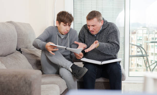 istock Father and teen son solve school assignment together 1138109833