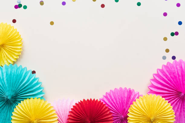 istock Paper flowers on light table top view. Festive or party background. Flat lay style. Copy space for text. Birthday greeting card. 1138112816