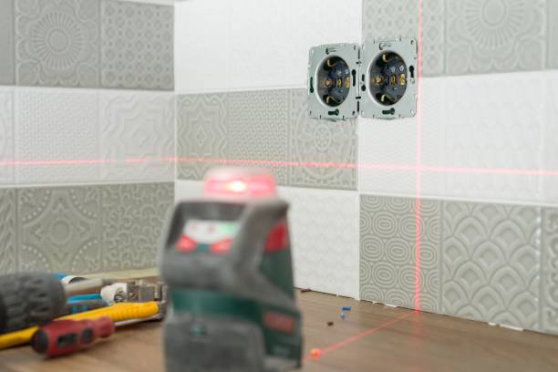 istock Electrician using infrared laser level to install electrical outlets. Renovation and construction in kitchen 1138113882