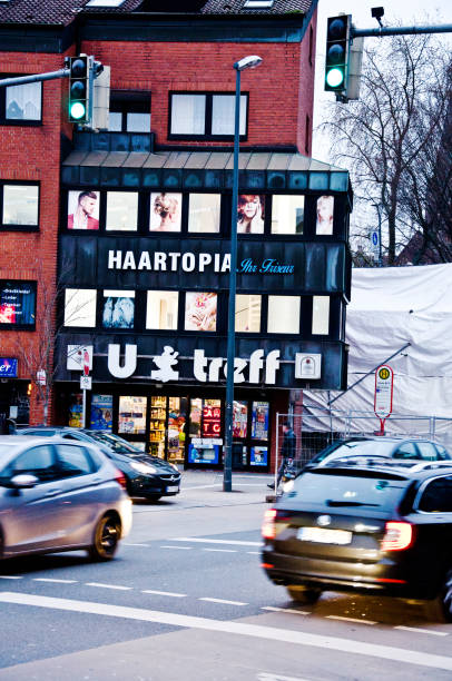 автомобили и пассажиры на автомобильном перекрестке в дортмунде hoerde bahnhof - германия. рекламные знаки (haartopia saloon) на заднем плане - 3844 стоковые фото и изображения