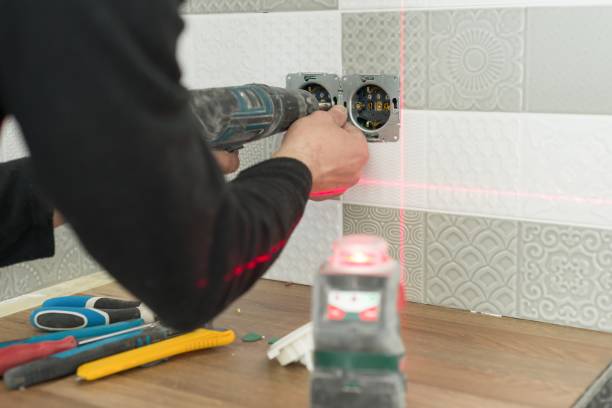 istock Electrician using infrared laser level to install electrical outlets. Renovation and construction in kitchen 1138114521