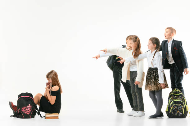 маленькая девочка сидит одна на полу и страдает от издевательств. - bullying child teasing little boys стоковые фото и изображения