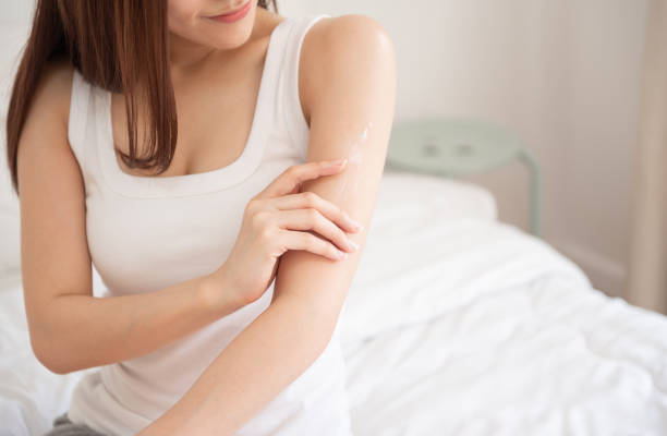 istock woman applying body lotion on her arm. 1138117806