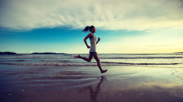 istock Female athlete running at sunset on beach 1138121445