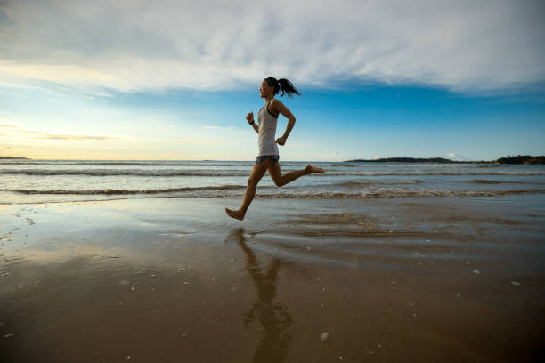 istock Female athlete running at sunset on beach 1138121561