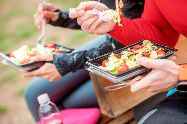 istock Two people using plastic eating utensils to eat a healthy protein salad from a plastic casing 1138122659