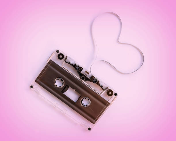 audiocassetta traslucida con il nastro magnetico a forma di cuore isolato su sfondo rosa, concetto di amore musicale - short phrase audio foto e immagini stock