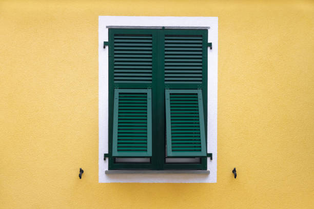 istock green wooden window with shutters in a white frame on the yellow wall 1138124701