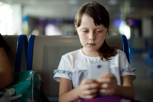 istock Serious girl texting while waiting for a flight at airport 1138125395