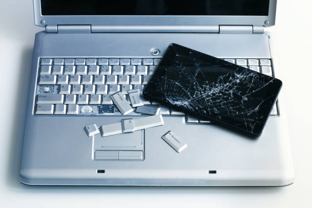 istock A silver laptop with a broken keyboard and a tablet with a cracked display. A close-up picture of part of broken laptop and cracked screen on a tablet. 1138127323