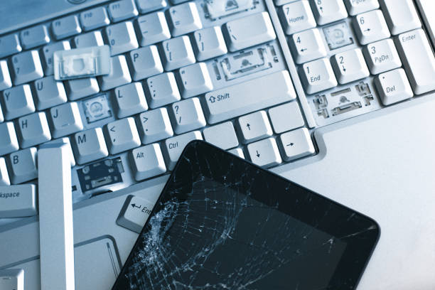 istock A silver laptop with a broken keyboard and a tablet with a cracked display. A close-up picture of part of broken laptop and cracked screen on a tablet. 1138127338