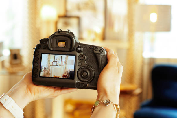 Closeup on DSLR camera in hand of female interior photographer Closeup on modern DSLR camera in hand of modern female interior photographer at home. digital single lens reflex camera stock pictures, royalty-free photos & images
