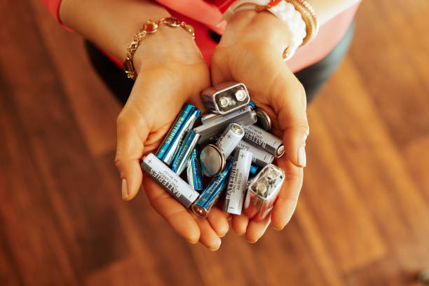 Closeup on different types of batteries in hand of housewife Closeup on different types of batteries in hand of modern housewife in the house. battery stock pictures, royalty-free photos & images