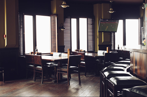 Modern trendy interior of pub, bar stools, tables, daylight. Concept football bar.