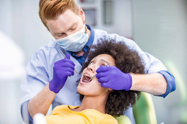 istock Dentist using an excavator sickle probe and a mouth mirror to perform a dental check up 1138133582