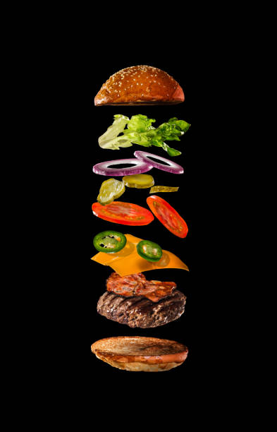istock Tasty hamburger with flying ingredients on dark background 1138134588