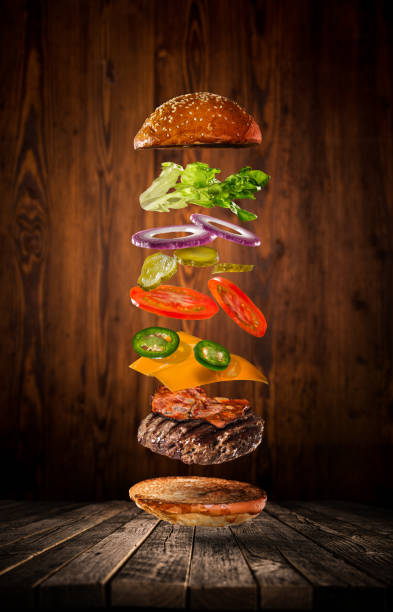 istock Tasty hamburger with flying ingredients on dark background 1138134601