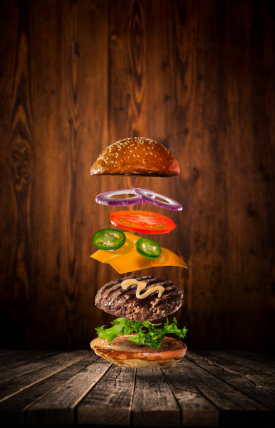 istock Tasty hamburger with flying ingredients on dark background 1138134612