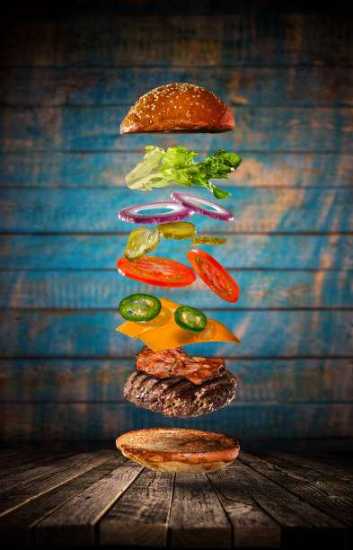 istock Tasty hamburger with flying ingredients on dark background 1138134621