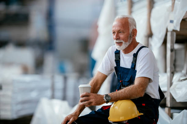 Senior factory worker having coffee break