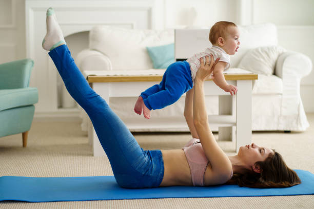 mutter trainiert zu hause zusammen mit babyssohn - relaxation exercise child mother human pregnancy stock-fotos und bilder