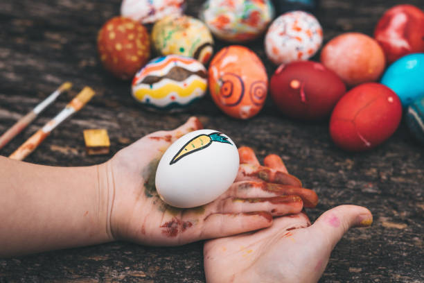 istock little girl holding easter egg in hands on wooden background 1138137908