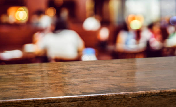 istock Wood table with people dinner at restaurant blur background.Empty perspective hardwood bar with blur coffee shop with bokeh light,Mock up for display or montage of product,Banner or header for advertise on online media. 1138138040