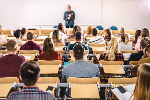 vista posteriore di un grande gruppo di studenti in una lezione in aula. - anfiteatro foto e immagini stock