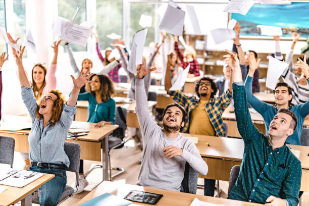 istock Large group of cheerful students having fun while celebrating the end of a class in the classroom. 1138139310