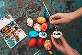 woman painting colorful easter eggs