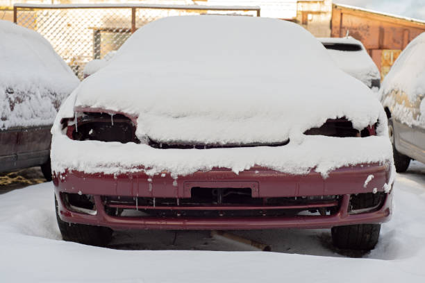 Front of abandoned car covered with snow
