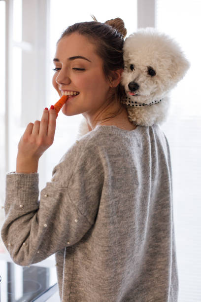 istock Girl eating carrot while holding her dog 1138142185