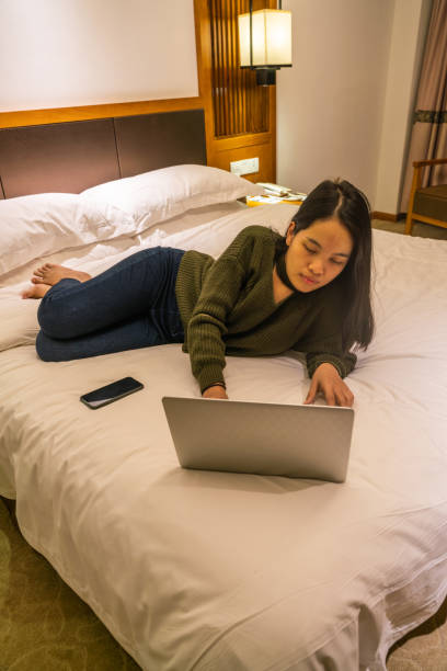 istock Asian woman lying on bed and using laptop 1138143733