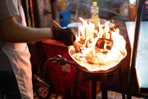 istock Chef hand cooking with fire pan, street food 1138143737