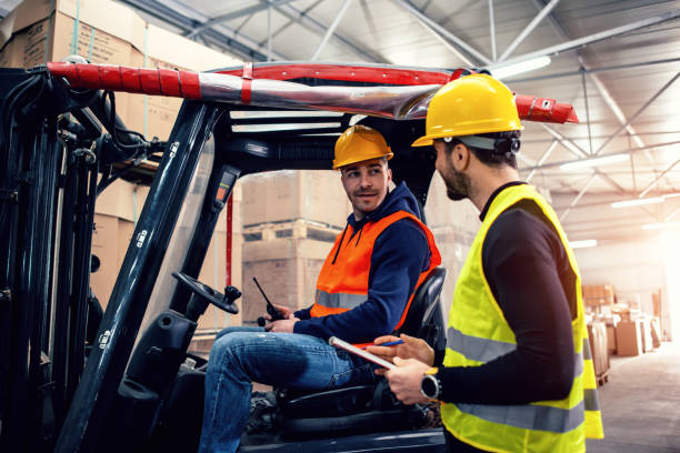 Workers in warehouse with forklift Workers in warehouse with forklift directing photos stock pictures, royalty-free photos & images