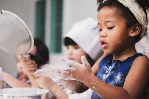istock Group diversity kids girl making cake bakery in kitchen 1138145277