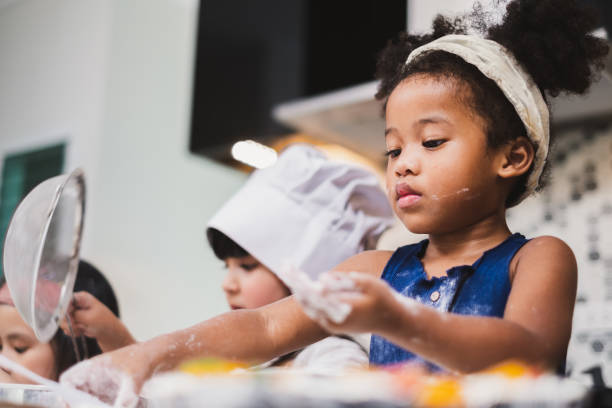 istock Group diversity kids girl making cake bakery in kitchen 1138145321