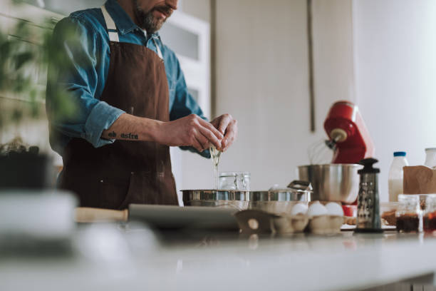 istock Close up of man pouring egg into the bowl while cooking 1138147630